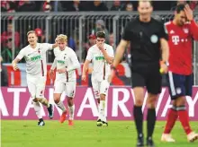  ?? Reuters ?? Augsburg’s Felix Goetze celebrates with teammates after scoring the equaliser against his former club Bayern Munich in the 1-1 draw on Tuesday.