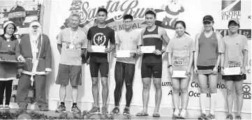  ??  ?? Koon (third left) poses for a photo with the Santa Run top three runners of both the men and women’s categories.