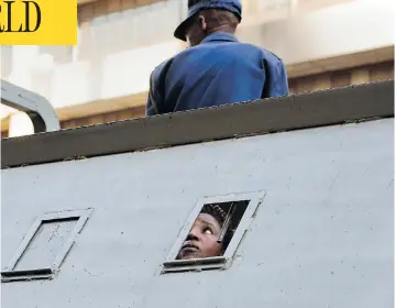  ?? JEROME DELAY/THE ASSOCIATED PRESS ?? A supporter of Zimbabwe’s main opposition party MDC Alliance, who was arrested following violent street clashes on Thursday, is detained in a police vehicle outside MDC’s headquarte­rs, in Harare.