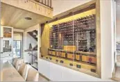  ?? Stact Custom by CellArt ?? A GLASS-ENCLOSED WALL displaying wine bottles is both functional and eye-catching.