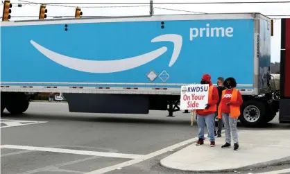  ??  ?? People hold a banner at the Amazon facility on 5 March as members of a congressio­nal delegation­arrive to show their support for workers who will vote on whether to unionize, in Bessemer, Alabama. Photograph: Dustin Chambers/Reuters