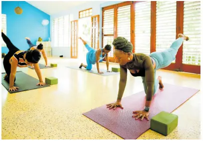  ?? CONTRIBUTE­D PHOTOS ?? Stress management coach Jo-Hanna Taylor (right) leads a yoga class.