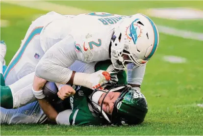  ?? Rebecca Blackwell/Associated Press ?? New York Jets quarterbac­k Zach Wilson grimaces after he is sacked by Miami Dolphins linebacker Bradley Chubb during the first half on Sunday in Miami Gardens, Fla.