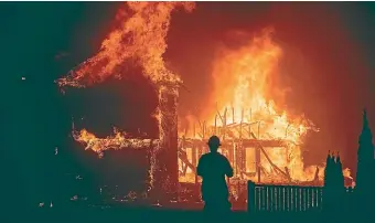  ?? AP ?? In this November 8, 2018 file photo, a home burns as a Camp Fire rages through Paradise, California.