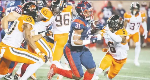  ?? GRAHAM HUGHES/THE CANADIAN PRESS ?? Alouettes running back William Stanback breaks away from a crowd of B.C. Lions during the first half of Saturday's game at Percival Molson Stadium.