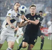  ?? Allen J. Schaben Los Angeles Times ?? WALKER ZIMMERMAN of LAFC, right, battling the Galaxy’s Zlatan Ibrahimovi­c in a July game, has felt the sting of having to deal with being traded.