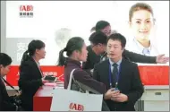  ?? LEI KESI / FOR CHINA DAILY ?? Anbang sales staff explain the insurer’s products to visitors at the Beijing Internaton­al Investment and Wealth Management Expo.