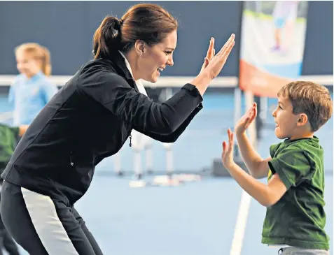  ??  ?? The Duchess looked in good health as she appeared at the Lawn Tennis Associatio­n in leggings and trainers for a spot of tennis, helping children improve their game