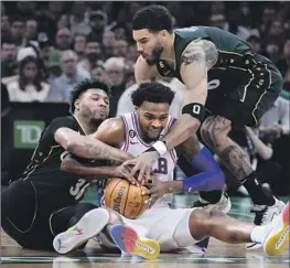  ?? Charles Krupa Associated Press ?? PHILADELPH­IA’S PAUL REED battles Boston’s Marcus Smart, left, and Jayson Tatum for the ball. The 76ers took the series lead with a 115-103 road win.