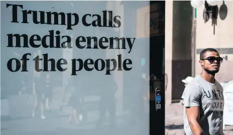  ?? JONATHAN NACKSTRAND/GETTY IMAGES ?? A man walks past an advertisin­g board reading “Trump calls media enemy of the people” on the day in July when the U.S. and Russian presidents held a private meeting in Helsinki, Finland. The billboard is one of hundreds sponsored by a Helsinki newspaper.