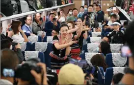  ?? LI JIAXIAN / CHINA NEWS SERVICE ?? Dancers wearing ethnic clothing entertain people aboard a train as the China-Laos Railway line began cross-border passenger service on April 13.