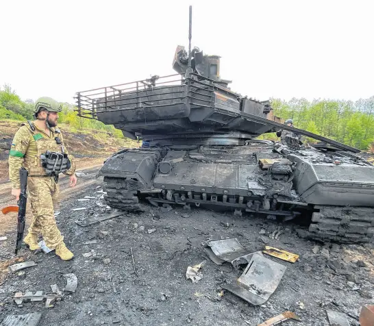  ?? REUTERS ?? A Ukrainian serviceman walks next to a destroyed Russian main battle tank T-90M Proryv, as Russia’s attack on Ukraine continues, near the village of Staryi Saltiv in Kharkiv region, Ukraine, on Monday.