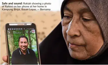  ?? — Bernama ?? Safe and sound: Rokiah showing a photo of Rahimi on her phone at her home in Kampung Binjai, Bayan Lepas.