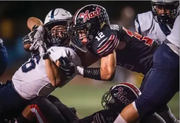  ?? Kevin Karzin/For The Signal (See additional photos on signalscv.com) ?? Saugus running back Reid Huseman (36) grinds out 3 yards as Hart High School’s Dylan Vradenburg (12) brings him down during the first quarter Friday at College of the Canyons.