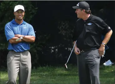  ?? Washington Post photo ?? The true measure of Friday’s showdown between Tiger Woods, left, and Phil Mickelson, right, is how many people pay $20 to watch the legends engage in a round of match play.