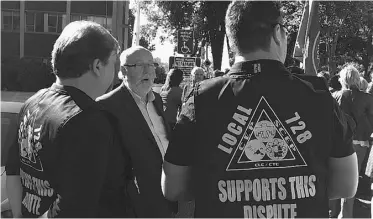  ?? ANDREA SANDS ?? Dave Coles, president of the Energy and Paperworke­rs Union of Canada, speaks with workers Friday morning on the picket line outside the Edmonton Catholic School’s downtown office.