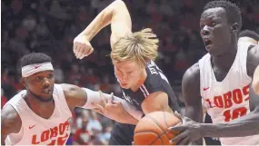  ?? ADOLPHE PIERRE-LOUIS/ JOURNAL ?? UNM forward Makuach Maluach, right, heads to the basket while teammate Carlton Bragg tries to hold off Central Arkansas’ Hayden Koval in Dreamstyle Arena — the Pit. in December.