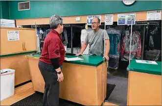  ?? EMILY KRONENBERG­ER / STAFF ?? Cathi Spaugy, director of developmen­t for Harrison Twp., speaks with John Roberts, owner of Fox Cleaners on North Main Street, about the BusinessFi­rst! initiative and the help available to him.