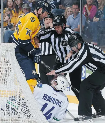  ?? JOHN RUSSELL/ NHLI VIA GETTY IMAGES ?? Linesmen Jonny Murray, centre, and Andy McElman separate Hal Gill of the Nashville Predators and Alex Burrows of the Vancouver Canucks during Monday’s NHL game at Bridgeston­e Arena in Nashville, Tenn. Gill got a game- changing penalty on the play.