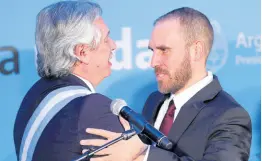  ?? AP ?? In this December 10, 2019 photo, President of Argentina Alberto Fernandez (left) embraces Martin Guzman after appointing him finance minister in Buenos Aires, Argentina.