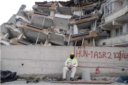  ?? PETROS GIANNAKOUR­IS/AP ?? A rescue worker rests Saturday as others continue the search for earthquake victims in Antakya, Turkey.