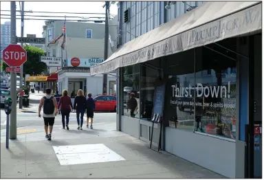  ?? (AP) ?? People walk past PlumpJack Wine & Spirits in San Francisco in this file photo. PlumpJack, founded by California Gov. Gavin Newsom, received a loan worth between $150,000 and $350,000 from the Paycheck Protection Program.