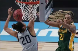  ?? ERIC GAY - THE ASSOCIATED PRESS ?? Baylor guard DiJonai Carrington (21) passes over UConn forward Olivia Nelson-Ododa (20) during the second half of a college basketball game in the Elite Eight round of the women’s NCAA tournament at the Alamodome in San Antonio, Monday, March 29, 2021.