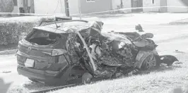  ?? SUN SENTINEL JOE CAVARETTA/SOUTH FLORIDA ?? The SUV that was struck by an airplane Monday stands behind police lines on a residentia­l street near North Perry Airport in Pembroke Pines on Tuesday.