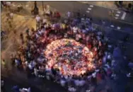  ?? THE ASSOCIATED PRESS ?? People gather Friday at a memorial tribute of flowers, messages and candles to the victims on Barcelona’s historic Las Ramblas promenade on the Joan Miro mosaic, embedded in the pavement where the van stopped after killing at least 13 people in...