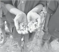  ??  ?? A girl shows some of the mica flakes she has collected whilst working in a open cast illegal mine in Giridih district in the eastern state of Jharkhand, India, January 22.