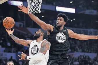  ?? [CHRIS PIZZELLO/THE ASSOCIATED PRESS] ?? Team LeBron’s Kyrie Irving, left, tries to make a layup around Team Stephen’s Joel Embiid during the Sunday’s NBA All-Star game.