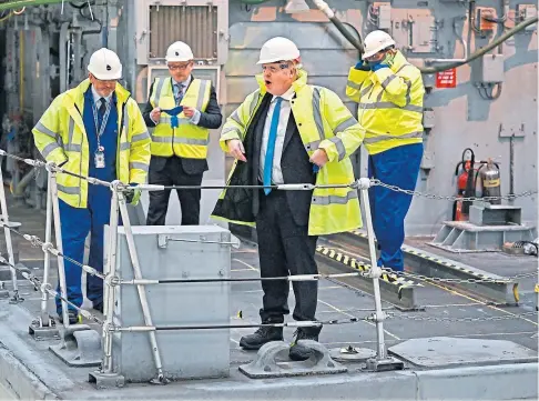  ?? ?? SEA VIEW: Boris Johnson watches a vessel being refitted for the Ukrainian navy on a visit to Rosyth dockyard yesterday.