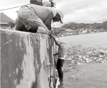  ?? VÍCTOR RAMÍREZ/LISTÍN DIARIO ?? Operativo. Empleados del Ministerio de Obras Públicas trabajan en la limpieza del Malecón de Samaná para despejar el área de desperdici­os y falicitar el curso del agua acumulada.