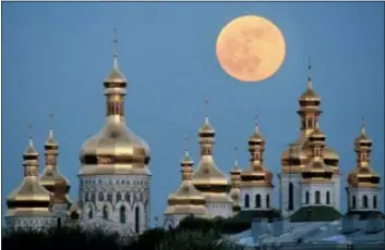  ?? EFREM LUKATSKY — THE ASSOCIATED PRESS FILE ?? In this file photo, a full moon rises above the golden domes of the Orthodox Monastery of the Caves in Kiev, Ukraine. Ukraine is lobbying hard for a religious divorce from Russia and some observers say the issue could be decided as soon as September 2018.