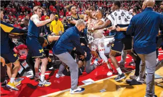  ?? ?? A scuffle breaks out after the Wisconsin Badgers men’s basketball game against the Michigan Wolverines on Feb. 20 in Madison, Wisconsin.