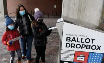  ?? BOsTON hErALd FILE ?? TAKING THE OPPORTUNIT­Y: Trish Bergin of Boston watches as her daughters Tess, 10, and Ellissa, 7, cast her ballot and her husband Kevin’s on Nov. 1 at a drop box outside City Hall.