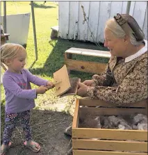  ?? PHOTO BY JAMIE DRAKE ?? Susan Youhn of Hollywood is showing a young visitor to Point Lookout how women carded fiber for yarn. Youhn has been a historical interprete­r for the past 28.5 years.