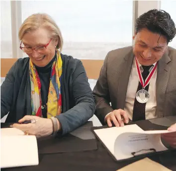  ?? MICHELLE BERG ?? Carolyn Bennett, minister of Crown-Indigenous relations and Chief Darcy Bear sign a framework agreement for a Whitecap Dakota treaty at Dakota Dunes Golf Links Clubhouse in Whitecap, on Monday.