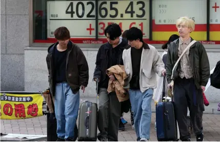  ?? AP PHOTO ?? BREACHING
People walk in front of an electronic stock board showing Japan’s Nikkei 225 index on Monday, March 4, 2024, in Tokyo. Japan’s Nikkei 225 share benchmark has topped 40,000 for the first time as strong demand for technology shares drives the index higher.