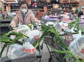  ?? LIU XIAO/XINHUA VIA AP ?? A worker on Wednesday prepares bags of vegetables to be delivered to households in Xi’an, China, which is under a strict lockdown.