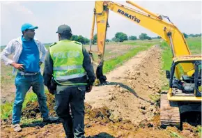  ??  ?? Policía patrulla la construcci­ón de un terraplén en donde antes había un humedal.