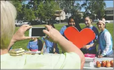  ?? NEWS-SENTINEL FILE PHOTOGRAPH ?? Project coordinato­r Lori Riley, far left, takes a picture of volunteers at Hyde Park during last year’s Love Lodi event on April 29, 2017. Pictured, from left: Ereyly Hernandez, 14, Yesneia Delatorre, 14, and Roxana Mendoza, 11.