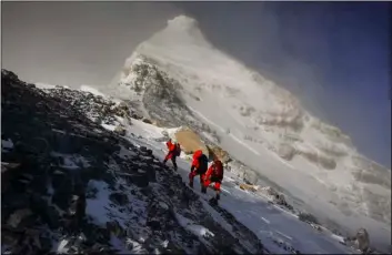  ?? TASHI TSERING/XINHUA VIA AP, FILE ?? In this May 27 file photo, released by Xinhua News Agency, members of a Chinese surveying team head for the summit of Mount Everest, also known locally as Mt. Qomolangma.