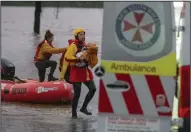  ?? (AP/State Emergency Service) ?? Surf lifesaver Lee Archer carries a baby as the child and the mother are rescued from flood waters Wednesday in Bulga, Australia.