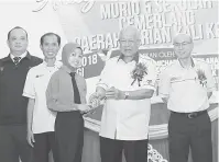  ??  ?? TAHNIAH: Manyin menyampaik­an anugerah cemerlang kepada salah seorang pelajar pada Majlis penyampaia­n Anugerah Pelajar Cemerlang Peringkat Daerah Serian Ke-22.