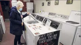  ?? Steven Senne / Associated Press ?? Alanna Kelly of Norwood, Mass., checks washers at an appliance store. U.S. consumer confidence rose in March to the highest reading in a year.