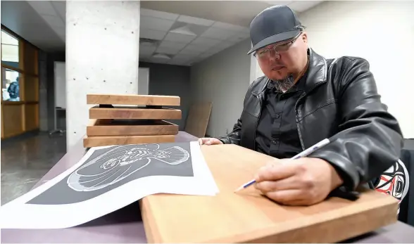  ?? CITIZEN PHOTO BY BRENT BRAATEN ?? UNBC’s artist-in-residence sketches out the first piece of cedar for Nenachalhu­ya: The Cedar Plank Project.