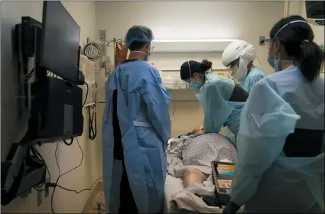  ?? JAE C. HONG — THE ASSOCIATED PRESS FILE ?? EMT Giselle Dorgalli, third from right, performs chest compressio­n on a patient who tested positive for coronaviru­s in the emergency room at Providence Holy Cross Medical Center in the Mission Hills section of Los Angeles, Nov.19.