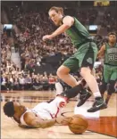  ?? The Canadian Press ?? Toronto Raptors’ DeMar DeRozan reaches for the ball as Boston Celtics’ Kelly Olynyk leaps over him during Friday’s game.