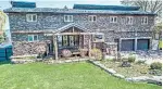  ??  ?? This two-storey home features a grey stone façade and an attached double car garage.